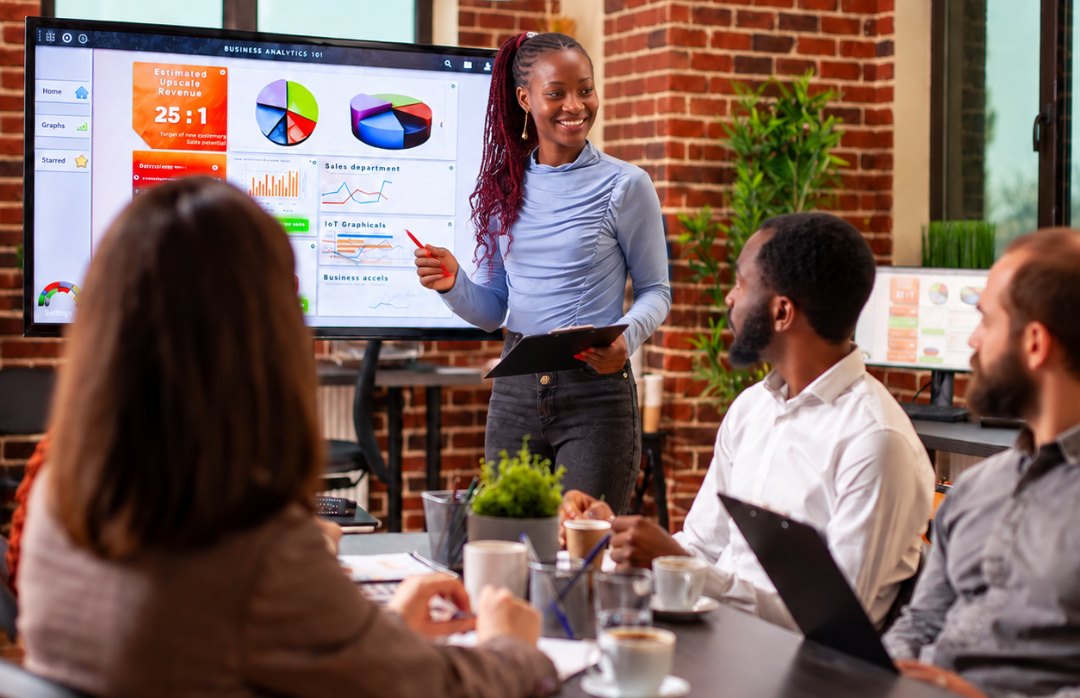 Team member presenting business analytics on a screen in a meeting